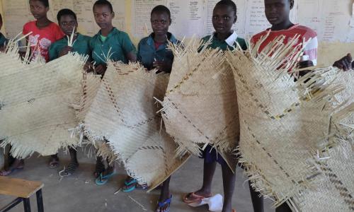 Some of the girls who board in the school display their beddings.