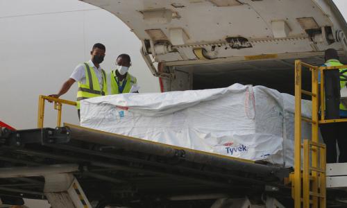 Staff unload the first shipment of COVID-19 vaccines distributed by COVAX at Kotoka International Ai