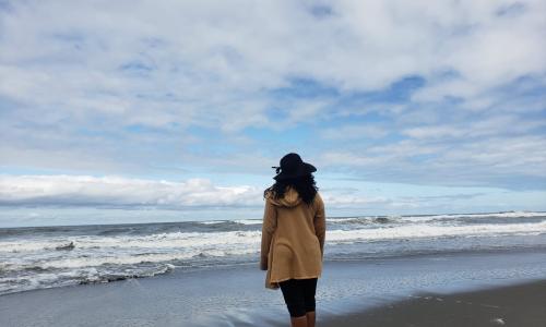 Dena M. Chasten standing on a beach. She found her birth parents and now works as a genealogist.