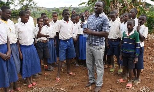 Wanafunzi kutoka shule ya msingi ya Minyinyi, nchini Tanzania na mwalimu wao ambaye anawafundisha kutumia kifaa cha kupima rutuba kwenye ardhi kwa ajili ya vipimo vya mbolea.